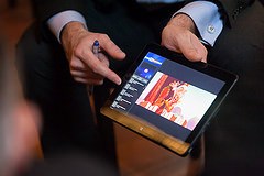 Photo of a man's hands holding a tablet