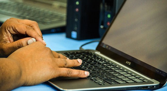 photo of human hands on the keyboard of a Dell XPS laptop notebook