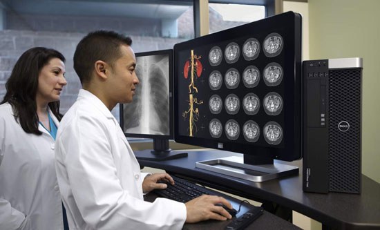 Woman and man reviewing medical images on monitor and Dell computer