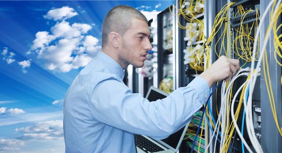 Harnessing the cloud for HPC: A man stands in front of a rack of servers with the sky behind him