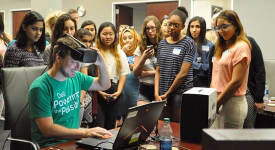 A group of girls watch a virtual reality demonstration during Girls Who Code field trip to Dell headquarters